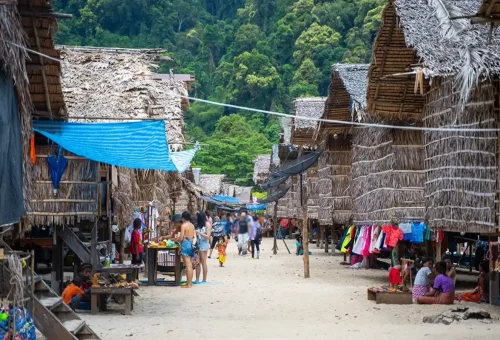 Moken villagers and tourists among traditional bamboo stilt houses in the Moken Village on Surin Islands.
