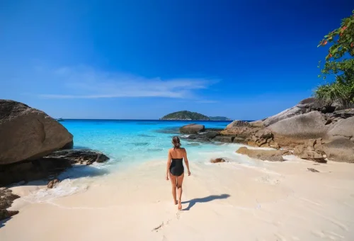 Tourists enjoying a tropical beach on Similan Islands under blue sky