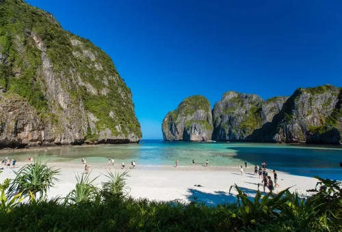 Visitors enjoying the white sand beach of Maya Bay