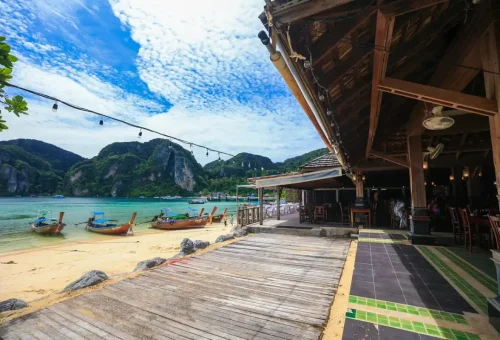 Rustic beachfront restaurant with longtail boats at Phi Phi