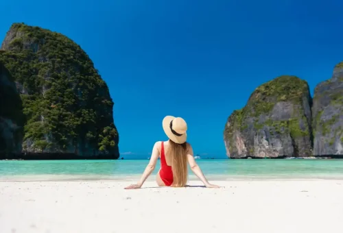 Woman in red swimsuit enjoying ocean views at Maya Bay