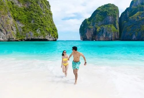 Romantic couple walking hand in hand on Maya Bay beach, Thailand