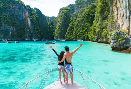 Couple on catamaran celebrating with raised arms in Phi Phi Islands