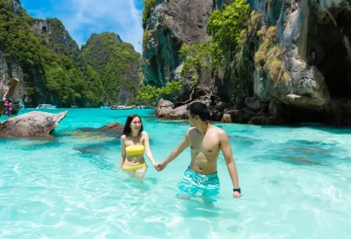 Couple enjoying turquoise waters and cliffs at Phi Phi Leh lagoon