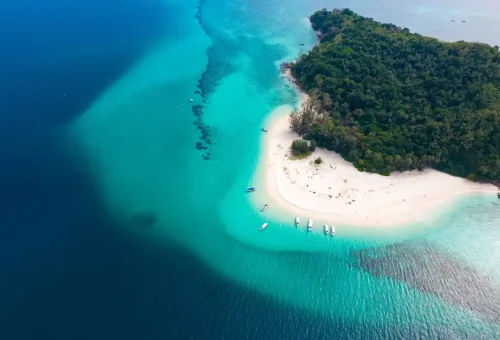 Aerial view of Bamboo Island’s white sand and coral-rich waters.
