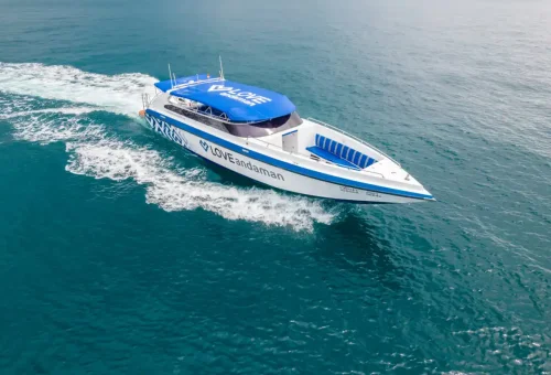 Modern white and blue speedboat by Love Andaman cruising through open sea.