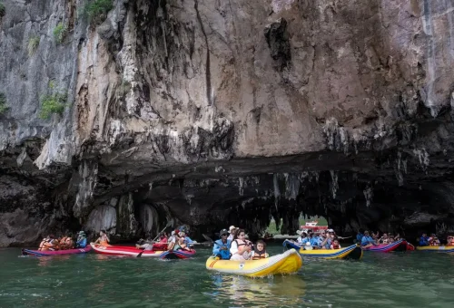 Group sea kayaking tour entering limestone cave at Hong Island