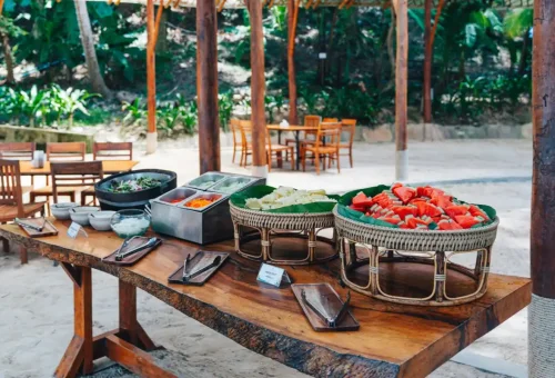 Tropical beachside buffet with fresh fruit and salad during the Racha and Coral Island tour.