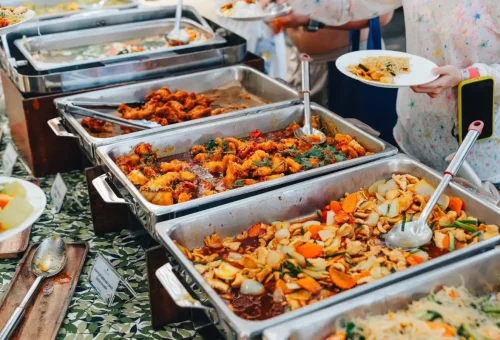 Colorful Thai buffet with curries, stir-fried dishes, and noodles served beachside.