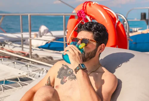 Man relaxing with a cocktail under the sun on the Ombre yacht
