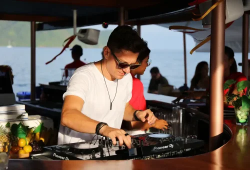 DJ playing live music on catamaran during sunset cruise