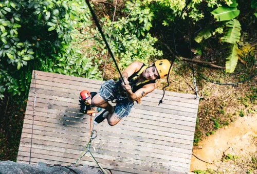 A man rappelling down a tree with professional climbing gear at Flying Hanuman, Phuket.
