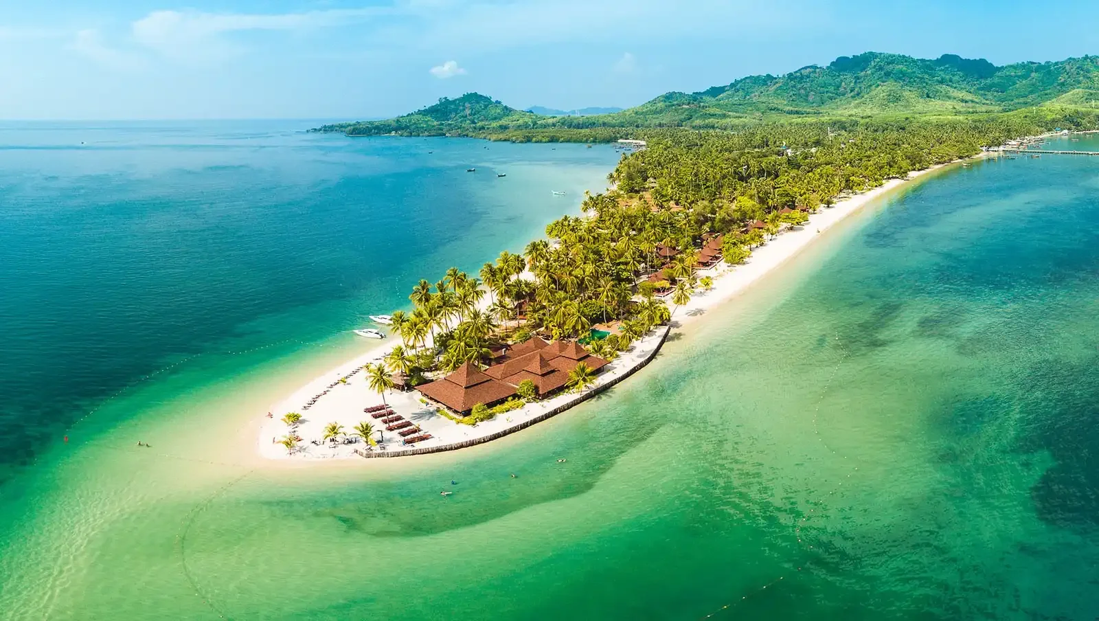 Aerial view of Koh Mook island with tropical beach, palm trees, and emerald green water in Thailand