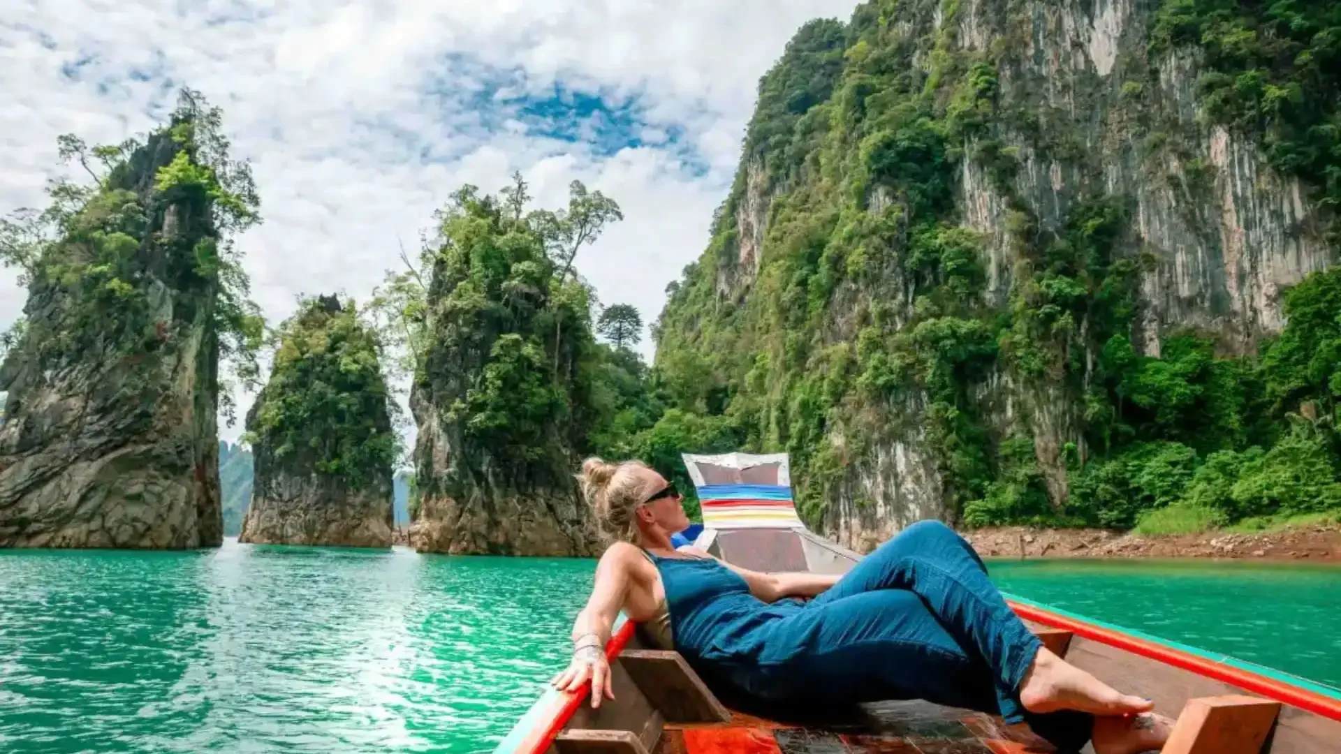 Panoramic view of Cheow Lan Lake at Khao Sok National Park with limestone cliffs and morning mist.