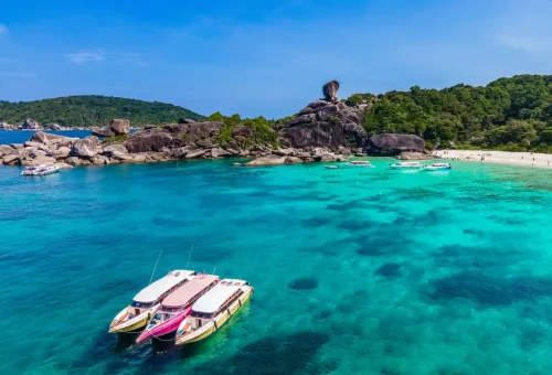 Speedboats anchored at Similan Islands with Donald Duck Rock and turquoise ocean, Thailand.