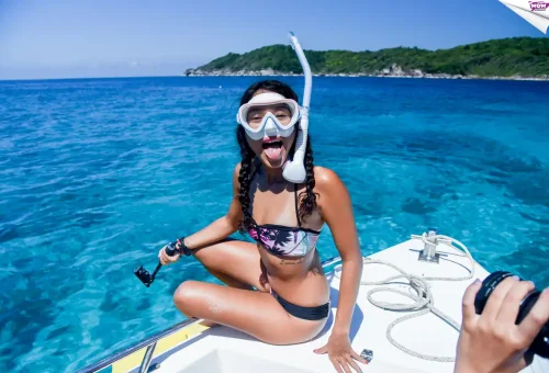 Happy snorkeler with mask and action camera on Wow Andaman boat in Similan Islands, Thailand.