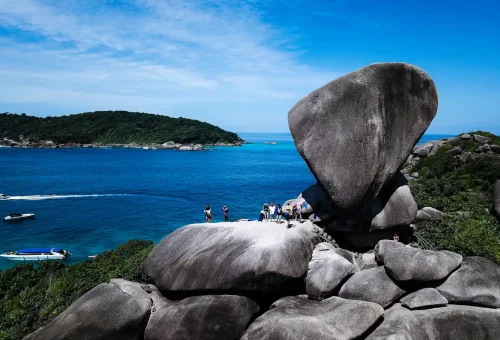 Tourists standing on the iconic Sail Rock viewpoint at Similan Islands Thailand.