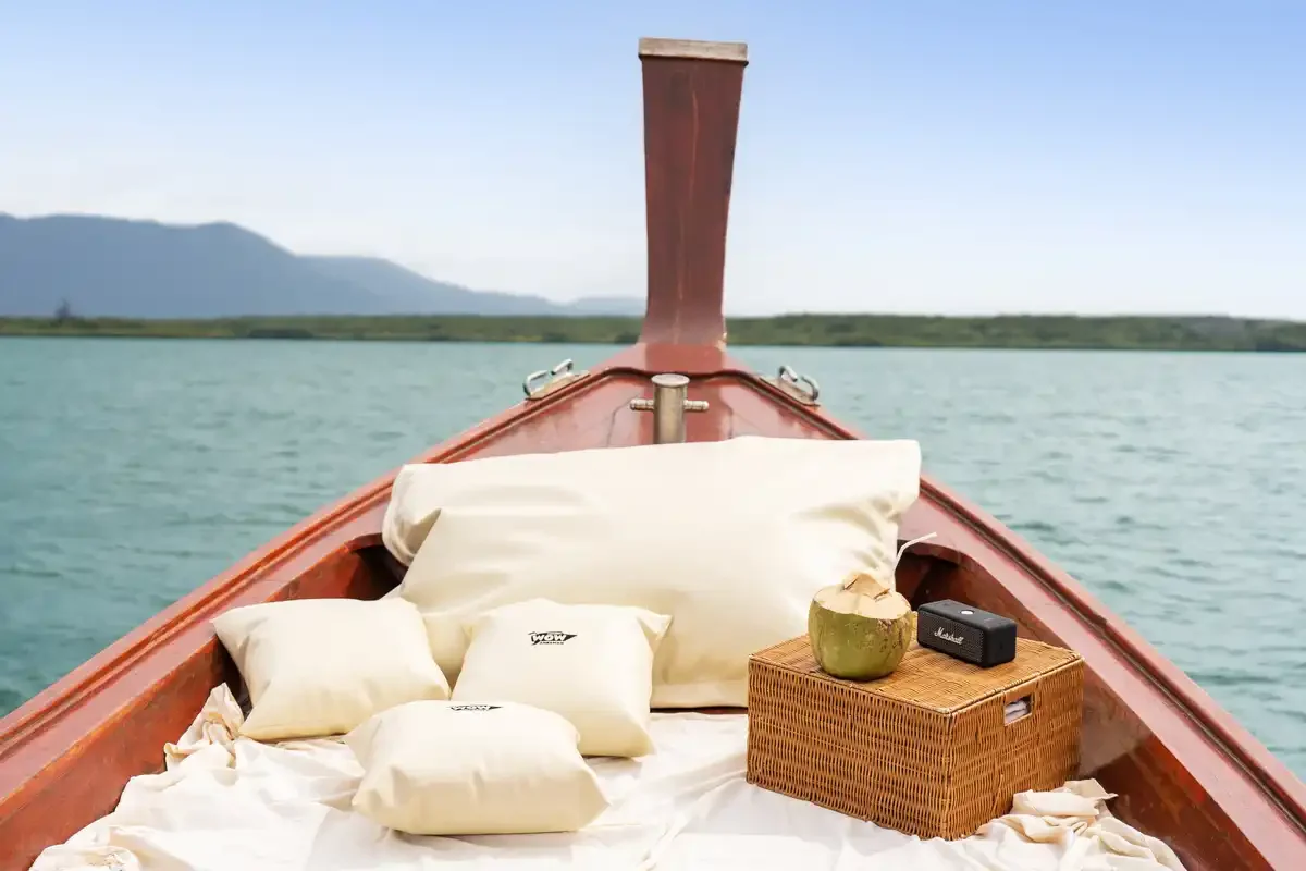 Cushions and coconut drink on a private longtail boat deck in Khao Na Yak.