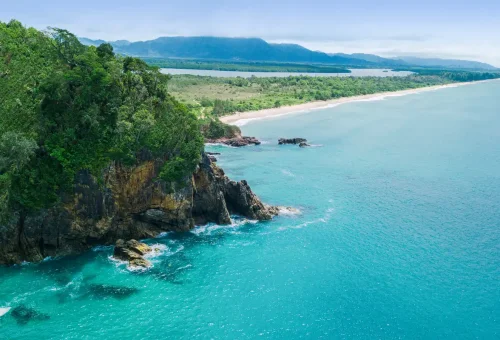 Rocky cliffs and lush green forest coastline of Khao Na Yak Phuket Travel Store.