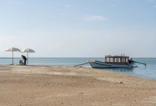 Private picnic setup with umbrellas and cushions on Pah Island beach.