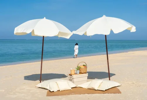 Two beach umbrellas with picnic setup on Pah Island during a private longtail boat tour.
