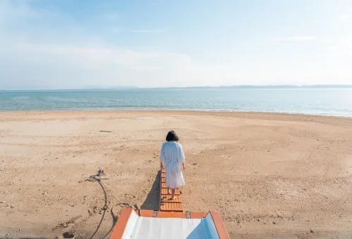 Woman walking barefoot on a deserted Pah Island beach during a private longtail boat tour.