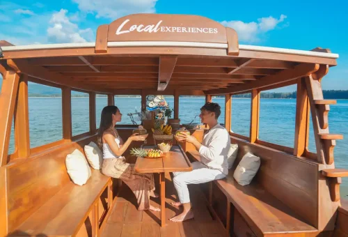 Couple enjoying fresh Thai fruits and drinks on a WOW Woco longtail boat tour in Phang Nga.
