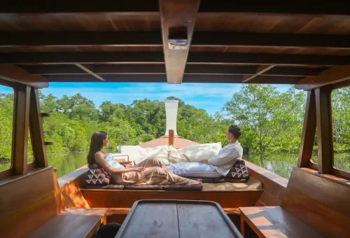 Couple relaxing on the deck of a WOW Woco private longtail boat in Phang Nga with Phuket Travel Store.