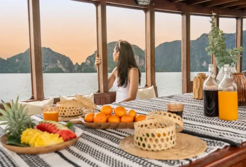 Woman looking out from WOCO boat towards limestone cliffs in Phang Nga Bay.