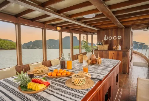 Private WOCO boat with Thai fruits and drinks set on deck in Phang Nga Bay.