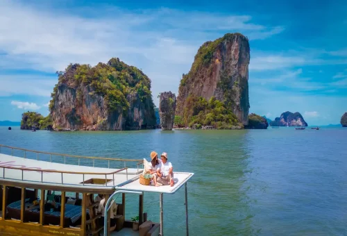 Couple sitting on private longtail boat with James Bond Island view