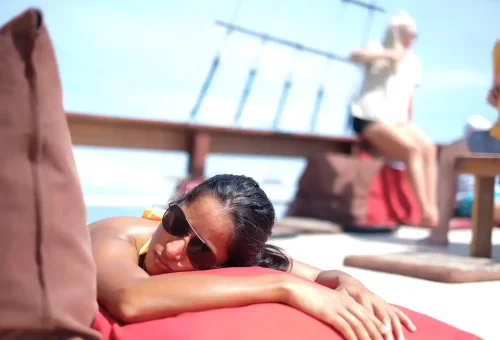 Guest sunbathing on cushion during The Cruise Day Tour Phuket