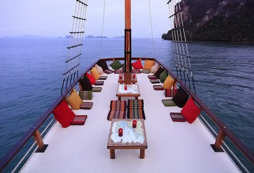 Candlelit tables and colorful cushions on sunset cruise deck