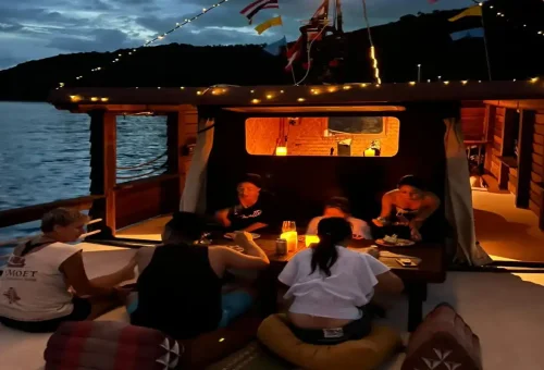 Guests enjoying cozy dinner on deck with candlelight
