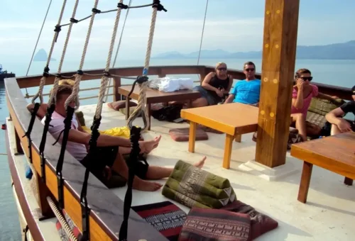 Group relaxing on shaded sundeck with pillows and tables