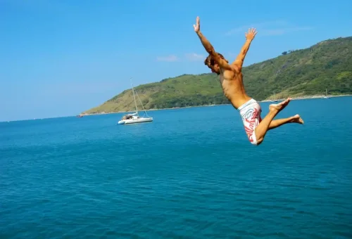 Traveler jumping from boat into the sea in Phuket