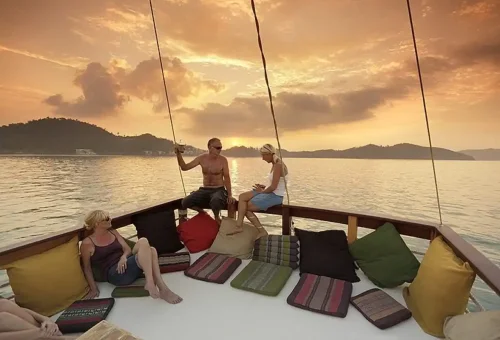 Couple enjoying drinks with friends during Phuket sunset cruise