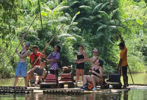 Group of travelers rafting together through lush jungle in Khao Sok.
