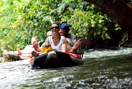 Smiling travelers enjoying canoeing adventure in Khao Sok National Park.