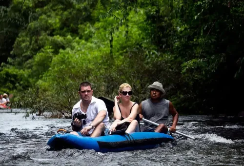 Tourists canoeing on the Sok River with local guide during Khao Sok jungle hiking and canoeing day trip.