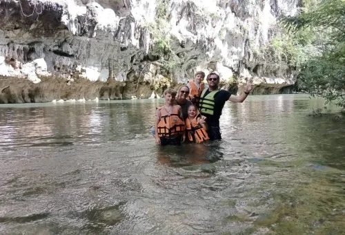 Family with children enjoying a river swim in Khao Sok National Park.