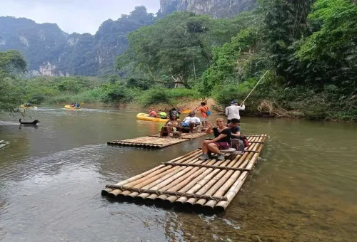 Travelers on a bamboo raft floating down Sok River in Khao Sok