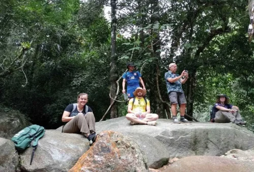 Tourists sitting on rocks during Khao Sok jungle hiking adventure