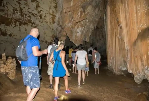 Tourists exploring a limestone cave at Cheow Lan Lake in Khao Sok National Park.