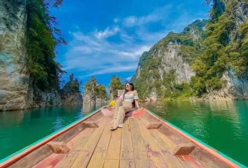 Traveler relaxing on a longtail boat at Cheow Lan Lake, Thailand.
