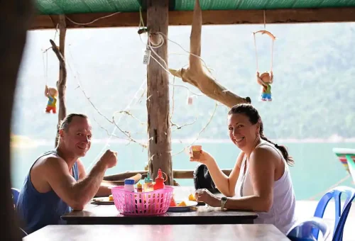 Tourists having traditional Thai lunch overlooking Cheow Lan Lake.