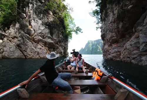 Longtail boat exploring limestone cliffs on Cheow Lan Lake day trip.
