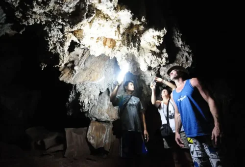 Travelers exploring mysterious cave formations at Cheow Lan Lake.