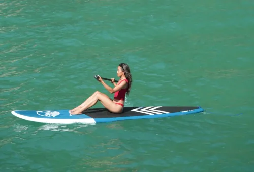 Traveler sitting on paddleboard enjoying calm emerald waters on Phang Nga Bay Sunset Serenity Cruise with Phuket Travel Store.