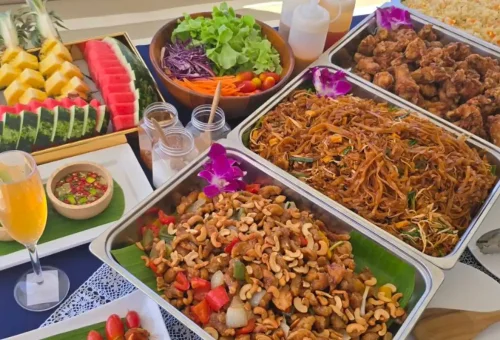 Buffet of Thai noodles, stir-fry cashew chicken, salads, and tropical fruits on Phang Nga Bay Sunset Serenity Cruise with Phuket Travel Store.